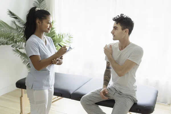 Black rehabilitation woman physiotherapy at physio clinic with customer — Stockfoto