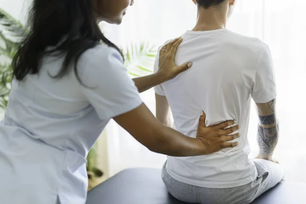 Preto reabilitação mulher fisioterapia na clínica de fisioterapia com o cliente — Fotografia de Stock