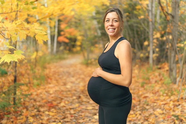 Ajuste mujer embarazada de pie fuera en un día soleado —  Fotos de Stock