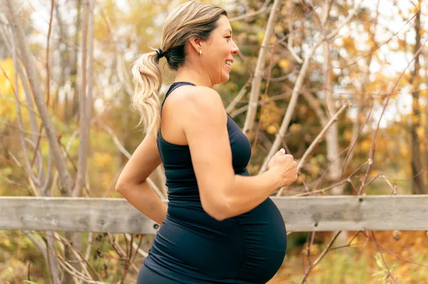 Adatta donna incinta in piedi fuori in una giornata di sole — Foto Stock