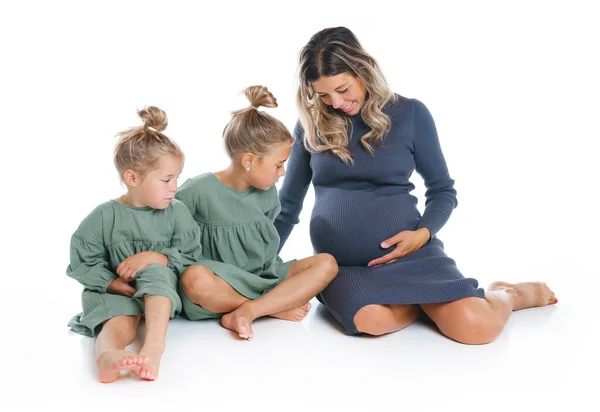 Two cute little sisters on the floor with pregnant mother — Foto Stock