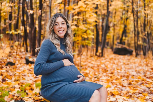 Autumn portrait of happy lovely and beautiful caucasian young pregnant woman in forest in fall color — Zdjęcie stockowe