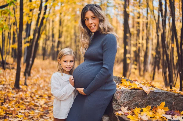 Pregnant mother and child on autumn nature outdoors — Zdjęcie stockowe