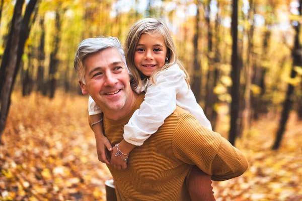 Father and daughter having fun in the autumn colorful forest — Stock Photo, Image