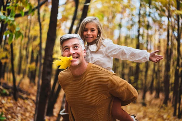 Father and daughter having fun in the autumn colorful forest — Stockfoto