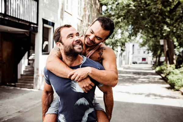 Un retrato de una feliz pareja gay al aire libre en el fondo urbano —  Fotos de Stock