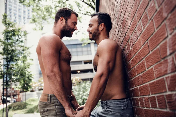 Ett porträtt av ett lyckligt homosexuellt par utomhus i urban bakgrund — Stockfoto