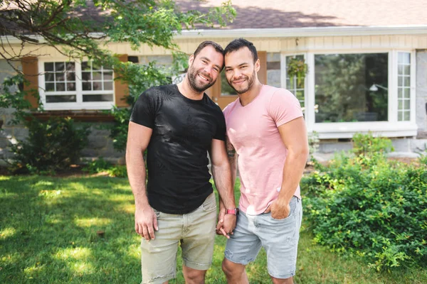 A Portrait of a happy gay couple outdoors in front of a new buy — Foto de Stock