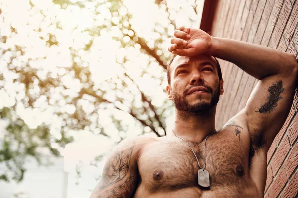 A shirtless man outside in a city street — Photo