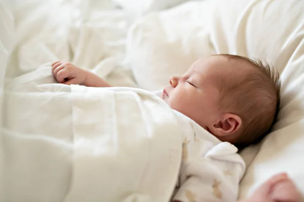 Una dolce neonata che dorme nel letto bianco — Foto Stock