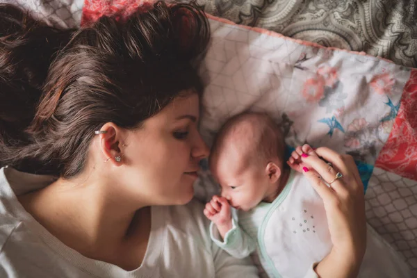 A Portrait of a beautiful mother with her newborn baby in the bedroom — Foto de Stock