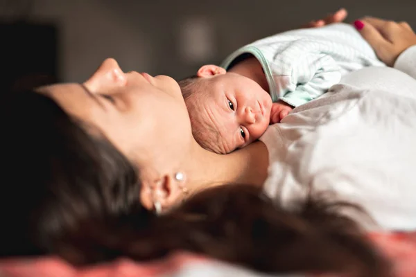 A Portrait of a beautiful mother with her newborn baby in the bedroom — Stok fotoğraf