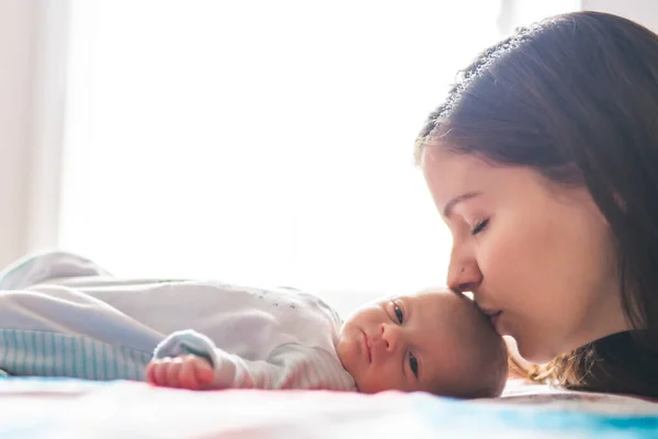 A Portrait of a beautiful mother with her newborn baby in the bedroom — Foto de Stock