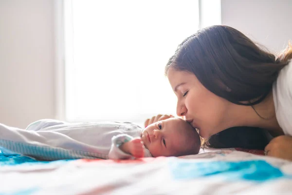 A Portrait of a beautiful mother with her newborn baby in the bedroom — Foto de Stock