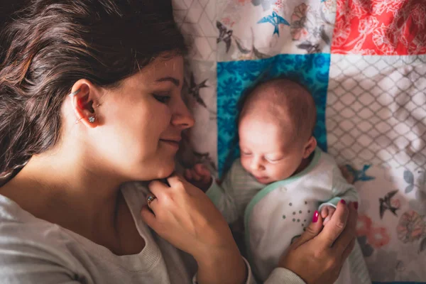 A Portrait of a beautiful mother with her newborn baby in the bedroom — Foto de Stock