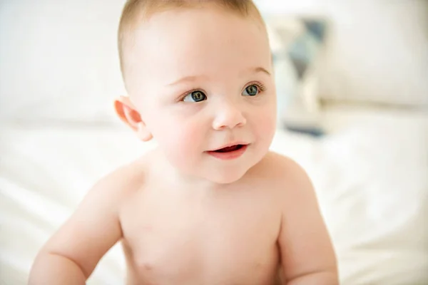 Cute baby boy lying on a white bed — Stock Photo, Image