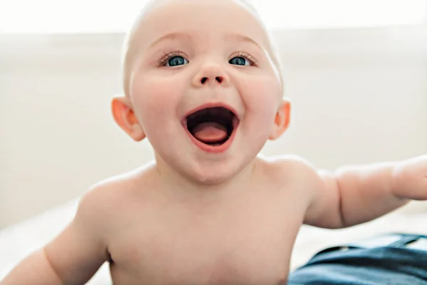 Sorpresa y feliz bebé en la cama en casa — Foto de Stock