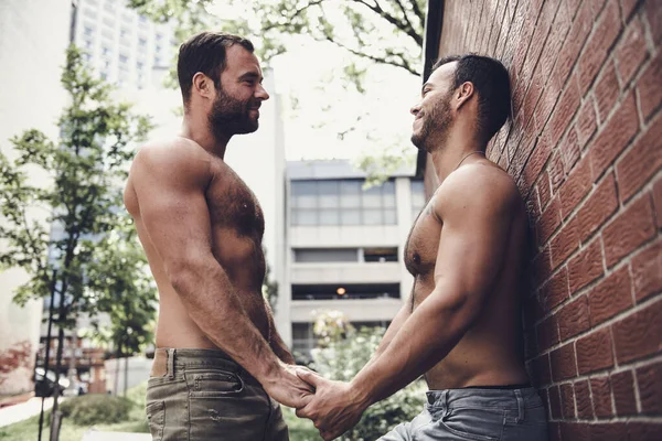 Un retrato de una feliz pareja gay al aire libre en el fondo urbano Imagen De Stock