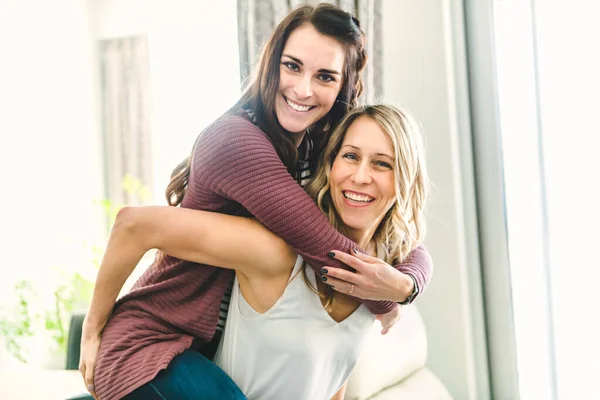 Duas namoradas felizes se divertindo em um piggyback — Fotografia de Stock