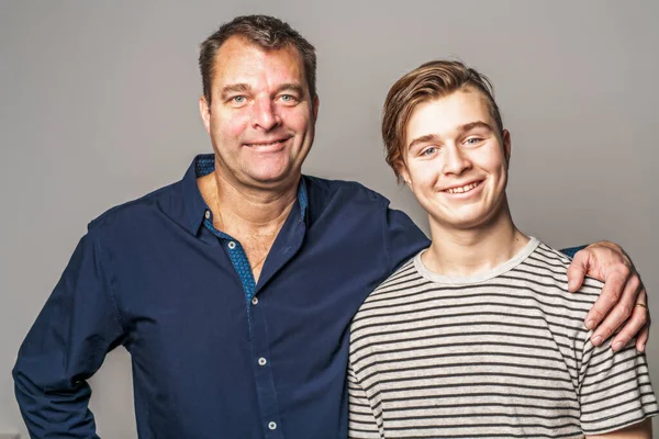 Ένας άνθρωπος και μια οικογένεια ευτυχισμένο αγόρι με τον πατέρα στο στούντιο γκρι φόντο — Φωτογραφία Αρχείου