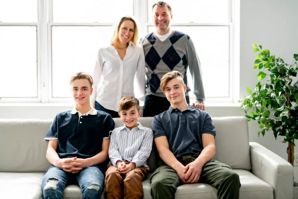 一个美丽快乐的家庭坐在家里的沙发上 — 图库照片