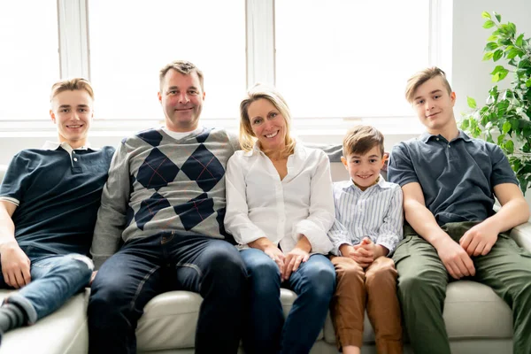 A Beautiful happy family sit on sofa at home — Stockfoto