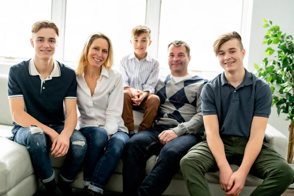 A Beautiful happy family sit on sofa at home — Stockfoto