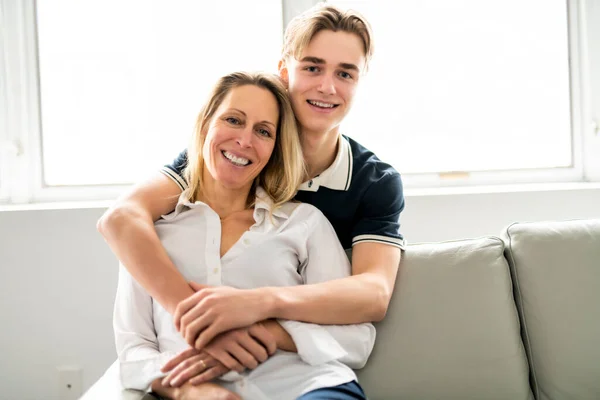 A people and family happy teen boy with mother on sofa at home — ストック写真