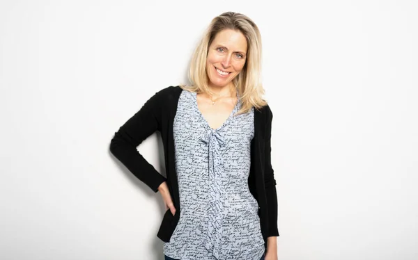 Confident and beautiful. Beautiful mature woman looking at camera and smiling while standing against white background — Stok fotoğraf