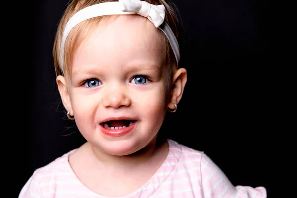A cute little girl two years old over dark background — Zdjęcie stockowe