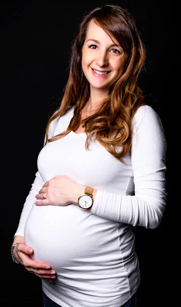 Una donna incinta vestito di bianco su sfondo scuro — Foto Stock