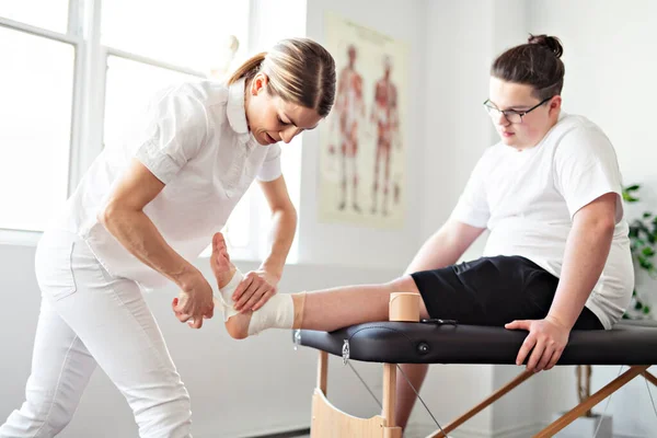 A Modern rehabilitation physiotherapy woman worker with client — Stockfoto