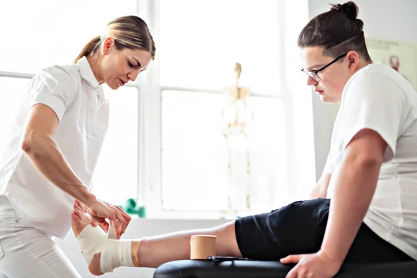 Una fisioterapia de rehabilitación moderna trabajadora con cliente — Foto de Stock