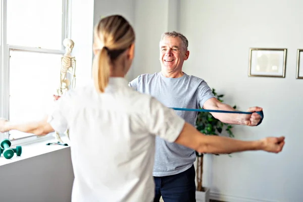 Moderní rehabilitační fyzioterapeutický pracovník se starším klientem — Stock fotografie