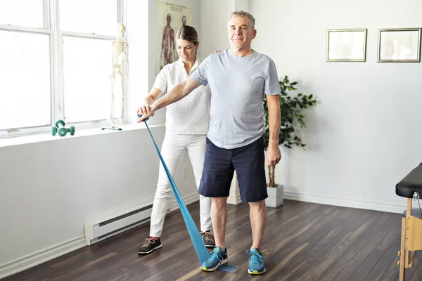 Un moderno fisioterapeuta de rehabilitación con cliente senior —  Fotos de Stock