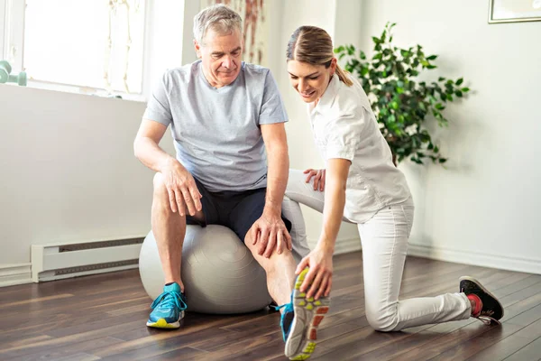 Moderní rehabilitační fyzioterapeutický pracovník se starším klientem — Stock fotografie