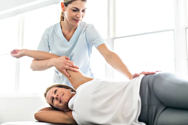 Un trabajador de fisioterapia de rehabilitación moderna con cliente mujer — Foto de Stock