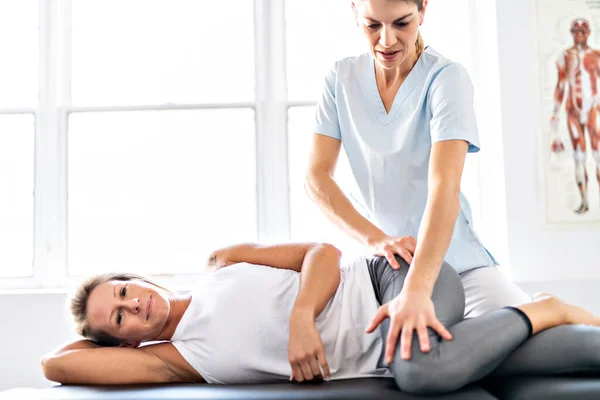 Un trabajador de fisioterapia de rehabilitación moderna con cliente mujer — Foto de Stock