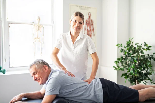 A Modern rehabilitation physiotherapy worker with senior client — Stock Photo, Image