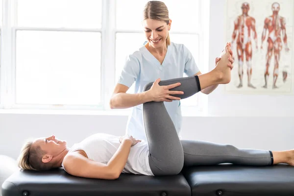 A Modern rehabilitation physiotherapy worker with woman client — Stock Photo, Image