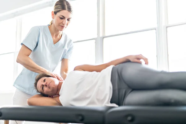 Un trabajador de fisioterapia de rehabilitación moderna con cliente mujer — Foto de Stock