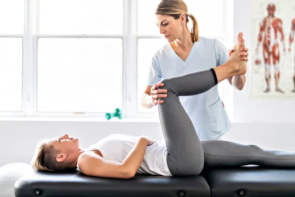 A Modern rehabilitation physiotherapy worker with woman client — Stock Photo, Image