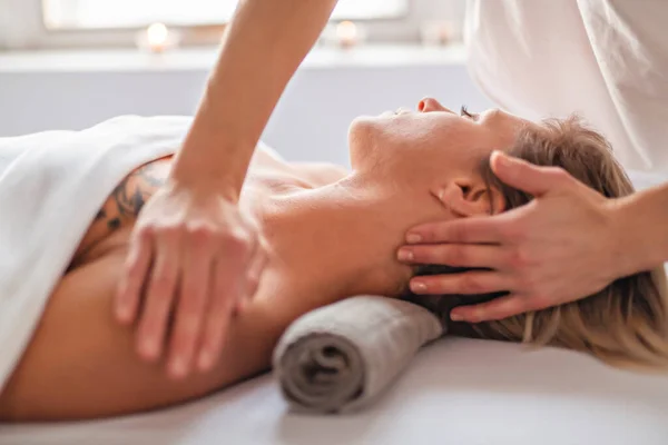 Een vrouw genieten van spa behandeling in salon met masseur werknemer — Stockfoto