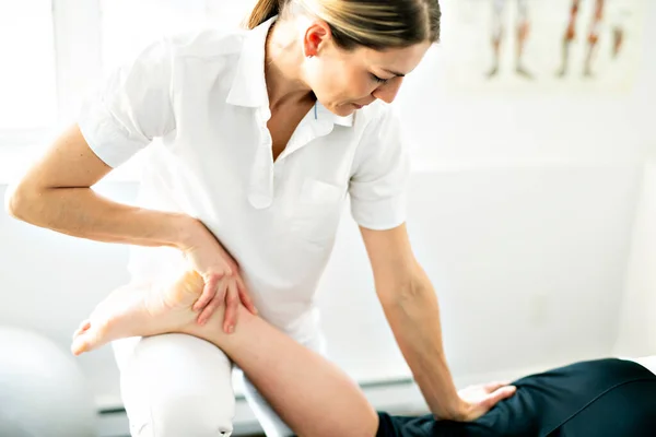 A Modern rehabilitation physiotherapy woman worker with client — Stockfoto