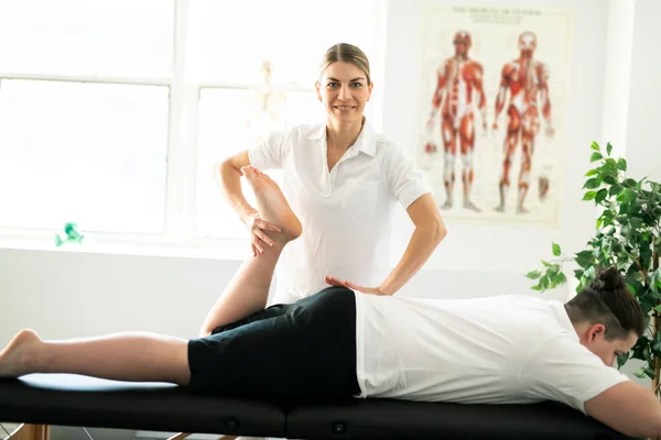 Moderní rehabilitační fyzioterapeutka s klientem — Stock fotografie