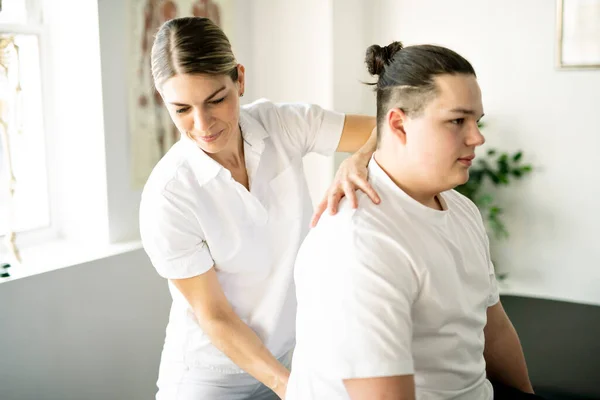 Una fisioterapia de rehabilitación moderna trabajadora con cliente — Foto de Stock