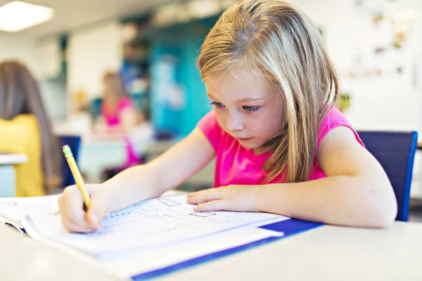 Education and school concept little student girl studying at school Stock Picture