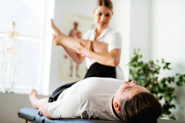 A Modern rehabilitation physiotherapy woman worker with client — Stockfoto