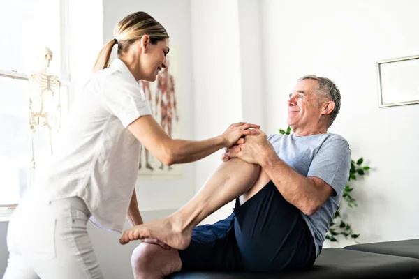 Een moderne revalidatie fysiotherapeut met senior klant — Stockfoto