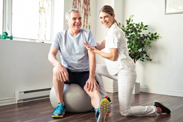 Moderní rehabilitační fyzioterapeutický pracovník se starším klientem — Stock fotografie